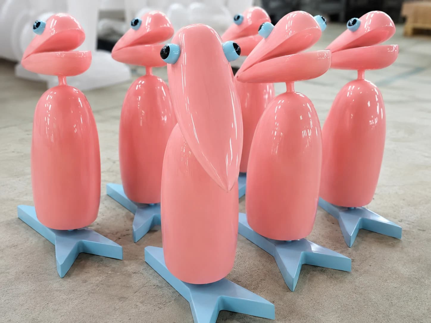 Close-up of repeated pink sculptural bird props with consistent high-gloss surface finishing.