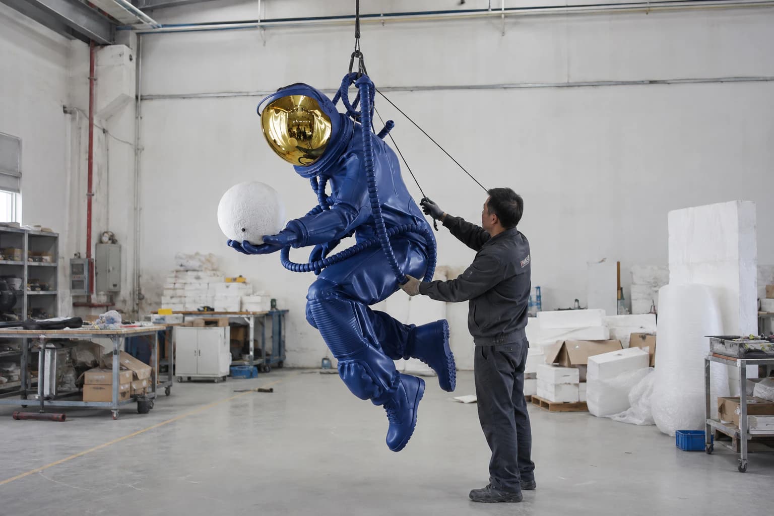 Suspended astronaut sculpture being checked in the workshop for hanging orientation, balance and posture.