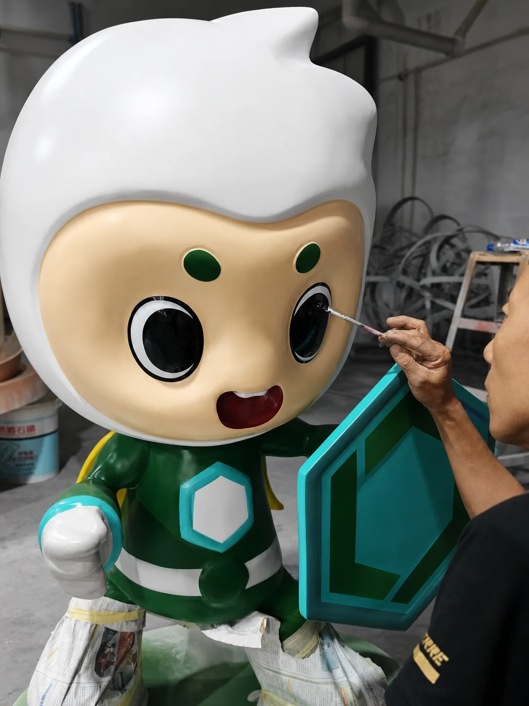 Hand finishing around the eye of a Treezo mascot sculpture