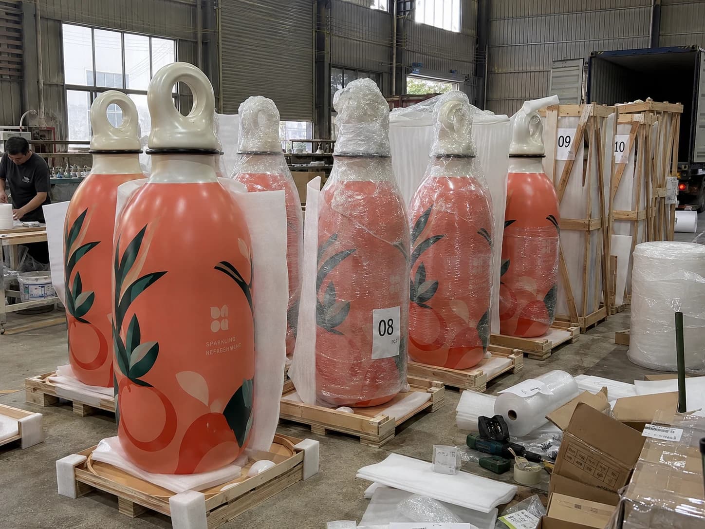 Oversized beverage replicas being protected and prepared for shipment