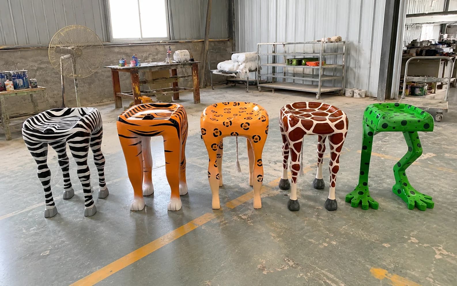 Five finished sculptural seating pieces with different animal patterns shown together inside the YAVIS workshop.