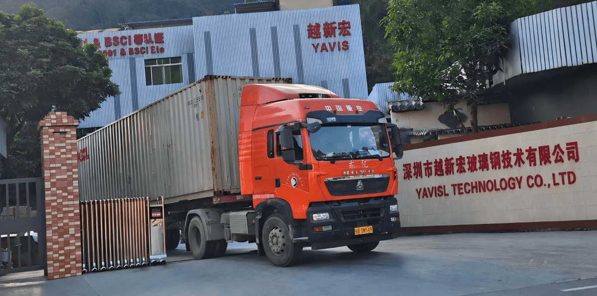Container truck outside the YAVIS factory entrance, with YAVIS building signage visible